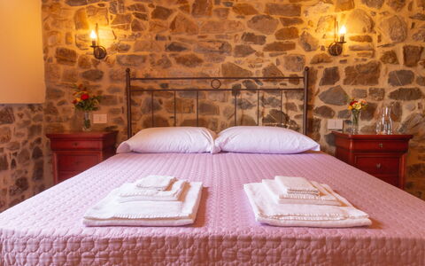 Marina's Lodge: Bedroom, Ceiling, Brick, Bedding, Stone Wall, Bed Sheet, Bed, Bed Frame, Linens, Wood Stain